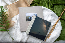 Hahnemuhle Baryta Bamboo fine art album from QTALBUMS with choice of personalizations. Pictured: linen cover with cameo and standard embossing (bottom), and our soft-touch Photo Panel cover style (top).